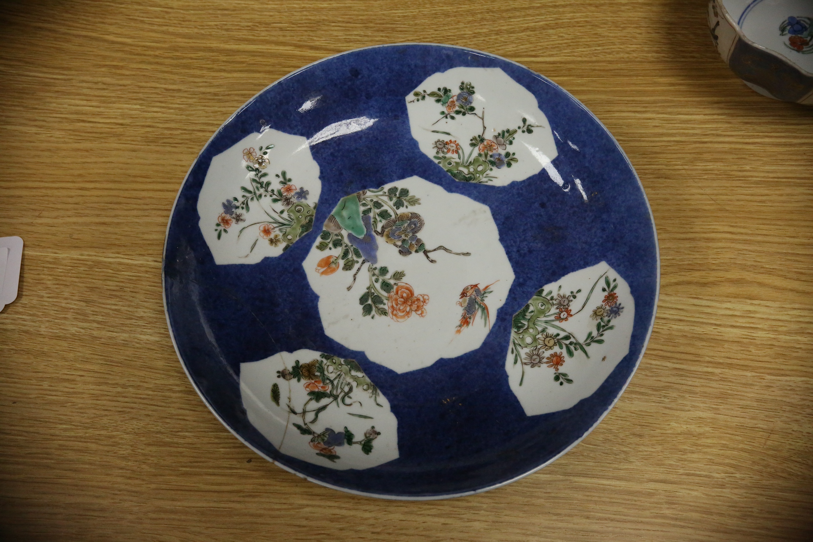 A Chinese famille verte powder blue ground bowl and a similar dish, both Kangxi period, 27.5cm diameter. Condition - dish poor, bowl fair